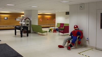 Väntrummet vid barnakuten med en spindelmannen-docka och ett fotbollsspel.
