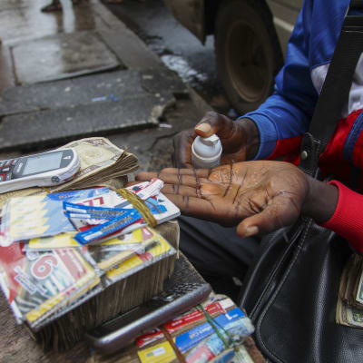 En gatuförsäljare i Liberia descinficerar sina händer.