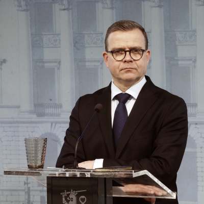 Statsminister Petteri Orpo (Saml) står vid ett talarpodium i statsrådsborgen och ser bestämd ut.