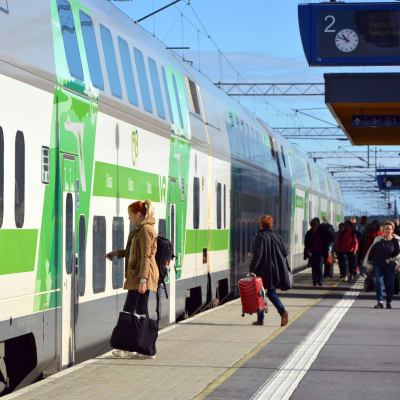 Folk går mot ett VR-tåg av typen Intercity på perrongen vid Bennäs tågstation