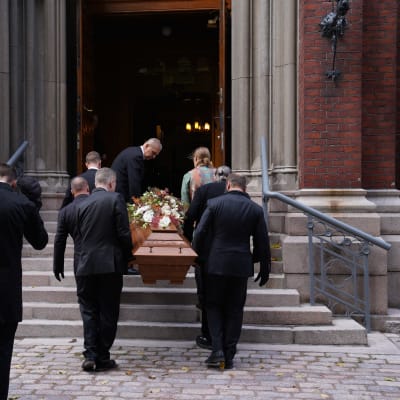 En kista bärs in i en kyrka.