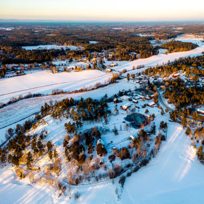 En flygbild över en by, det är vinter och det är snö på marken. 