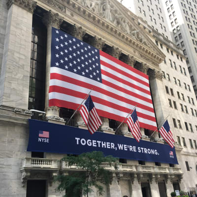 "Yhdessä olemme vahvoja"-teksti ja suuri Yhdysvaltain lippu rakennuksen seinässä.