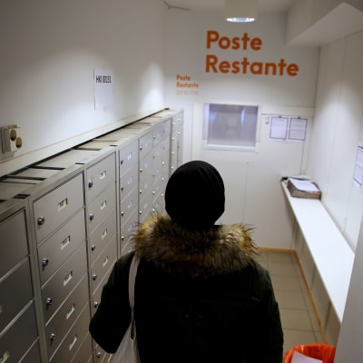 Asunnoton ihminen hakeaa postiaan poste restante -noutopisteestä Helsingissä.
