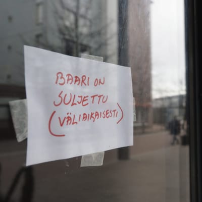 En lapp med texten "Baari on suljettu (väliaikaisesti)", på svenska "Baren är stängd (tillfälligt)".