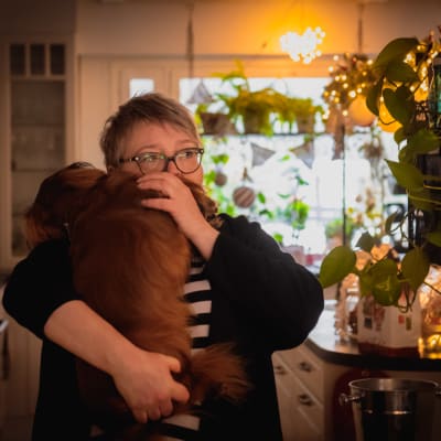 Arja Parviainen koira sylissään.
