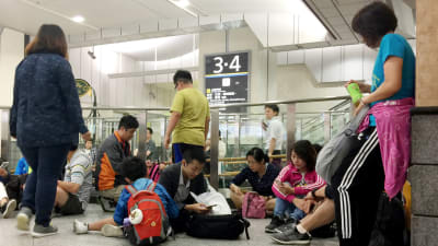 Passagerare på järnvägsstationen Shin-Osaka väntar på att trafiken ska återupptas efter skalvet den 18 juni 2019.