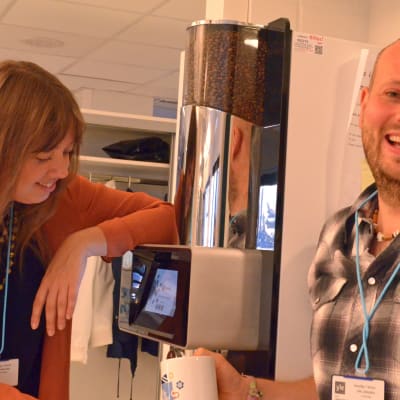 Mia Haglund och Calle Lindgren vid kaffeautomaten.