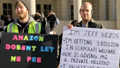 Två män demonstrerar mot Amazon och Jeff Bezos.