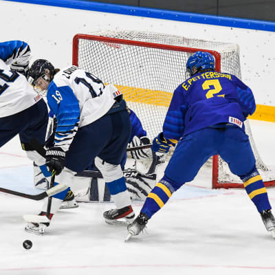 Finska spelare kämpar om pucken framför Sveriges mål. 