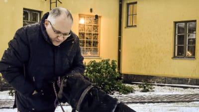 Man på knä med hund.