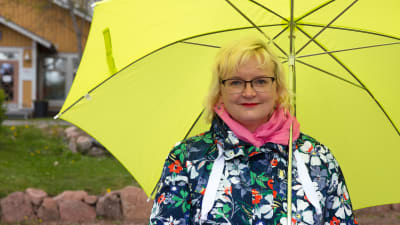 Lappträsks kommundirektör Tiina Heikka. En leende kvinna under ett gult paraply.