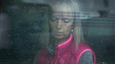 Maria med sänkt blick fotad genom en vår ruta.