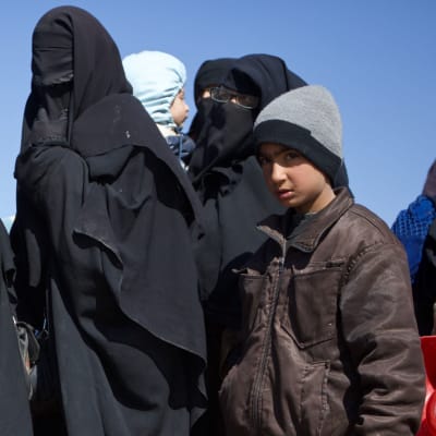 Naisia ja lapsia Syyriassa odottamassa siirtoa al-Holin leirille.