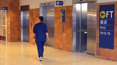 Sjukskötare går genom aulan i Vasa centralsjukhus på väg mot hissen