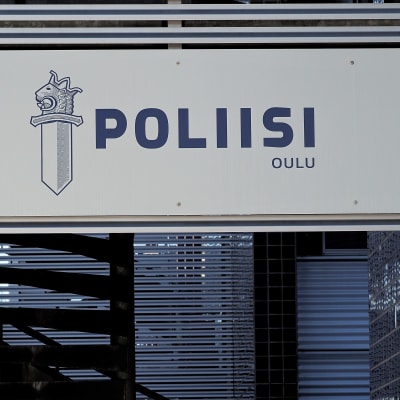 Valkoinen kyltti, jossa poliisin logo ja teskti: POLIISI, OULU.