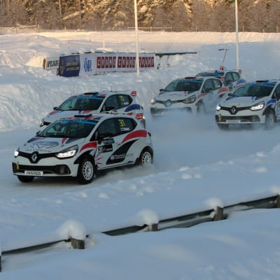 rallycrossbilar kör i hög fart på isbana.