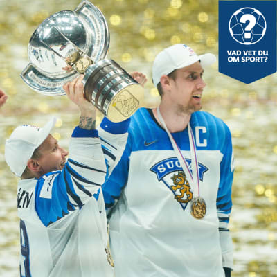 En hockeyspelare iklädd Finlands färger lyfter en pokal upp mot skyn. Guldfärgad konfetti syns i bakgrunden, liggande på isen.
