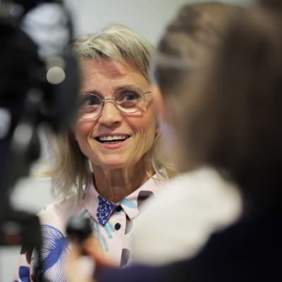 Leende Päivi Räsänen som möter ett medieuppbåd.  