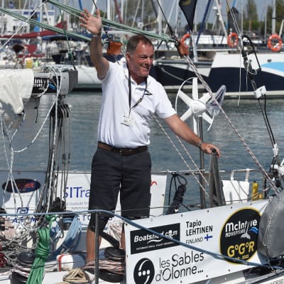 Tapio Lehtinen står på däck och vinkar.