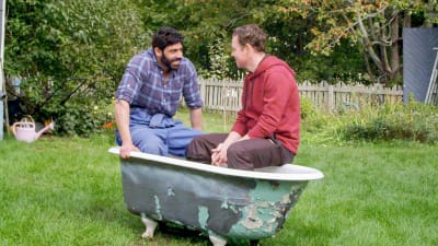 Mohamed (Bakr Hassan) och Christian (Patrick Henriksen) sitter i ett tomt badkar mitt på gräsmattan på en gård.