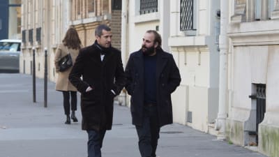 Förläggaren Alain (Guillaume Canet) och författaren Léonard (Vincent Macaigne) diskuterar medan de promenerar på en gågata. 