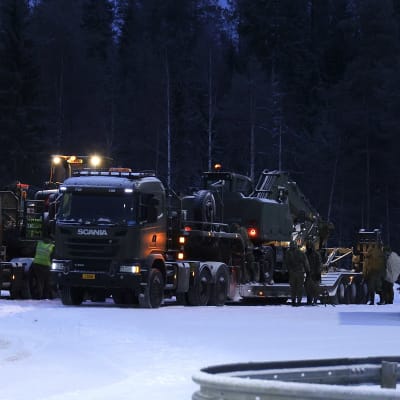 Lavettikuorma-autoja talvisella pihalla.