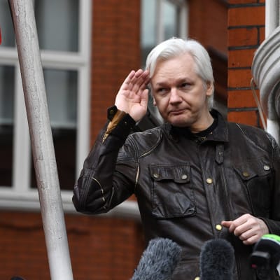 Julian Assange framför mikrofoner på ett presstillfälle utanför Ecuadors ambassad i London.