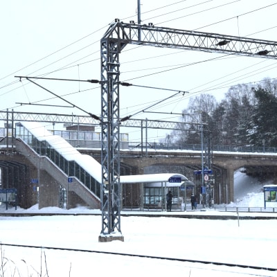 En vintrig dag på järnvägsstation i Karis där man ser järnvägsbron.