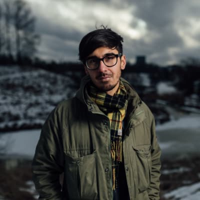 adrian perera står med en vintrig bakrund bakom sig