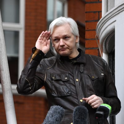 Julian Assange framför mikrofoner på ett presstillfälle utanför Ecuadors ambassad i London.