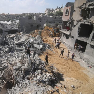 Gazabor undersöker skadorna på ett hus som har förstörts i en flygräd.