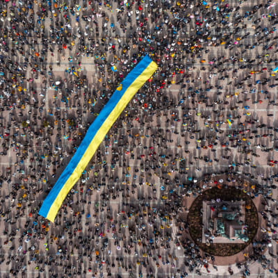 Ilmakuva Ukrainan lippua kannattelevasta yleisömerestä.