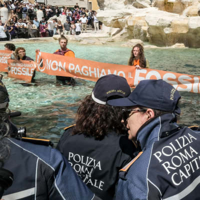 Demonstranter som protesterade mot fossila bränslen färgade Fontana di Trevis vatten svart.