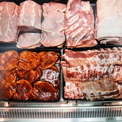 Närbild på en köttdisk med olika köttbitar i en affär.