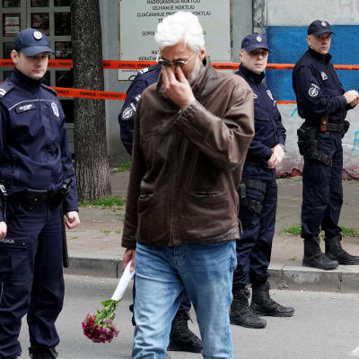 En man med en blombukett efter en skottlossning på en skola i Belgrad den 3 maj 2023.  