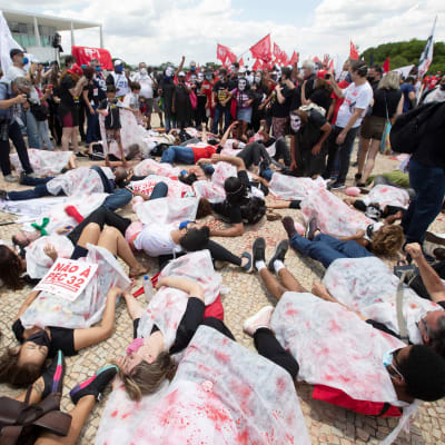 Demonstranter ligger på marken i staden Brasilia i protest mot statsledningens hantering av coronapandemin 
