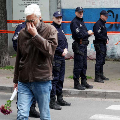 En man med en blombukett efter en skottlossning på en skola i Belgrad den 3 maj 2023.  