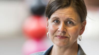 en kvinna i brunt uppsatt hår och jeansjacka