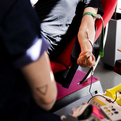En person som ger blod i Sanoma-husets blodtjänst.