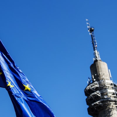 Kuvassa liehuu Euroopan unionin lippu, taustalla näkyy Pasilan linkkitorni.