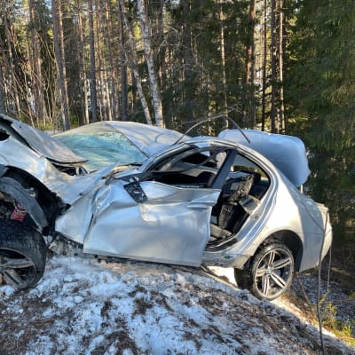 Pahoin romuttunut kolariauto tien sivussa.
