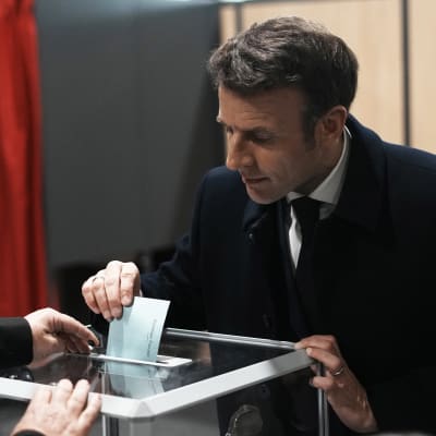 Presidentti Emmanuel Macron pudottaa äänestyslipukkeen uurnaan.