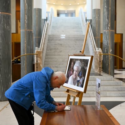 Mies kirjoitti nimensä surunvalittelukirjaa parlamenttitalossa Canberrassa Australiassa.