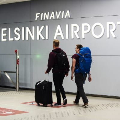 På bilden syns två resenärer på Helsingfors-Vanda flygplats.
