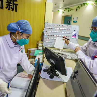 Sjukhuspersonal i skyddskläder och andningsskydd i ett sjukhus i Wuhan. Bilden är tagen den 30 januari 2020.