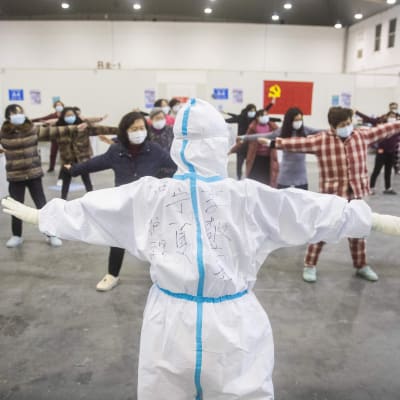 Medicinsk personal leder gruppgymnastik bland människor som smittats av coronaviruset och som tagits in på ett tillfälligt sjukhus och som uppvisar milda symptom av viruset. Bilden är tagen i Wuhan på måndagen. 