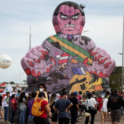Demonstration i Brasilien. Människosamling och en stor uppblåsbar figur som ska föreställa president Bolsonaro.