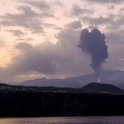 Bild på vulkan som spottar aska och spyr lava.