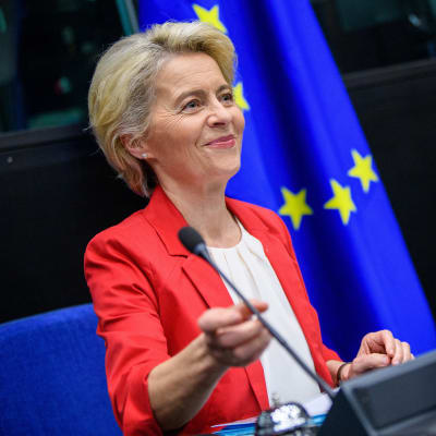 Närbild på EU-kommissionens ordförande Ursula von der Leyen vid kommissionens sammanträde i Strasbourg. I förgrunden ser vi en namnskylt och en vattenflaska, i bakgrunden den blågula EU-flaggan.